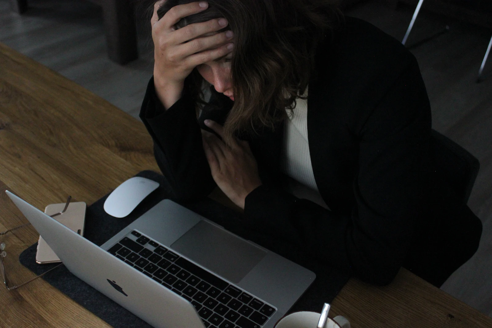 Person at a desk overwhelmed by messages on a phone